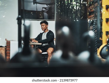 Hes Running This Gym Pretty Well. Cropped Shot Of A Handsome Young Male Fitness Instructor Using A Laptop While Working In A Gym.