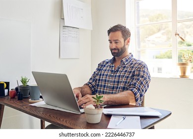 Hes A Self Made Success. Shot Of A Man Sitting At A Desk Working On A Laptop.