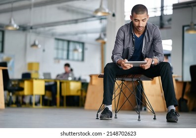 Hes a tech savvy young designer. Shot of a young man using a digital tablet while sitting in a modern office. - Shutterstock ID 2148702623