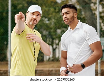 Hes weak on that side of the court. Cropped shot of a handsome male coach giving instructions to his younger tennis student on a court. - Powered by Shutterstock