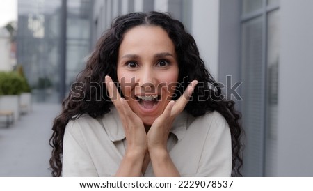 Hesdshot Oh my god wow female facial reaction close up. Amazed excited shocked wonder Caucasian woman girl raising hands in surprise unbelievable news victory winning looking at camera outdoors