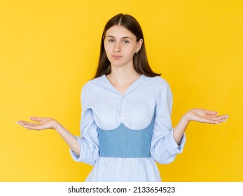 Hesitating woman. Helpless feelings. Unsure look. Doubtful pretty lady shrugging hands looking clueless isolated yellow.