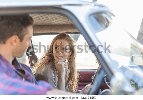 Heterosexual couple in\
car together,\
smiling