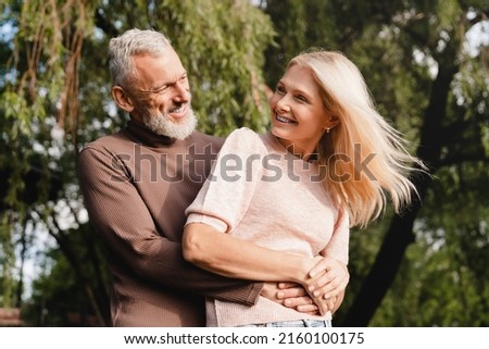 Heterosexual couple. Caucasian mature spouses hugging embracing together in city park on romantic date. Love and relationship concept.