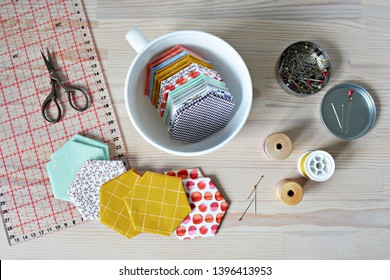 Hexagon Patchwork Templates, White Cup, Thread, Retro Scissors, Metal Pins And Quilting Ruler On The Wooden Table