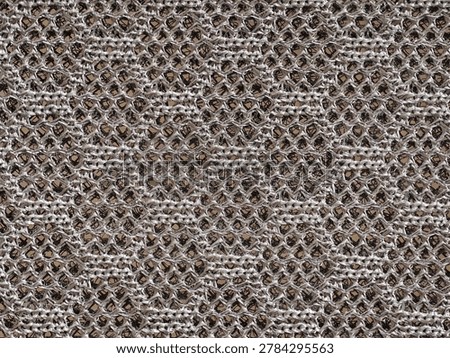 Hexagonal honeycomb knit texture closeup, repeating threedimensional stitch creating geometric relief
