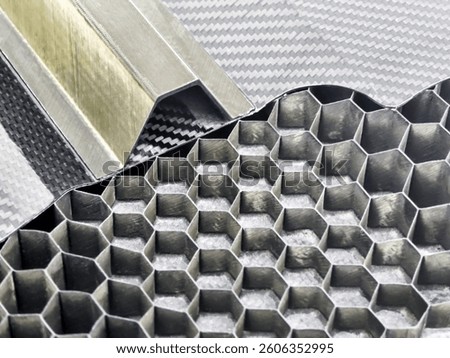 Hexagonal honeycomb patterns and metallic components are highlighted, revealing the intricate design and structure of carbon fiber materials used in various industries.
