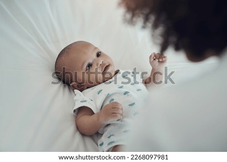 Hey mom, whatcha doin. Shot of an adorable baby girl gazing at her mother on the bed at home.