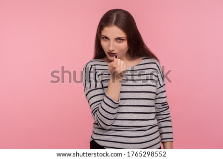 Hey you, approach to me! Portrait of attractive seductive woman in striped sweatshirt gesturing with one finger, come here symbol, enticing and beckoning. studio shot isolated on pink background Stock photo © 