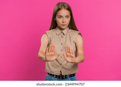 Hey you, be careful, slowly. Young woman warning with admonishing finger gesture, saying no, be careful, scolding and giving advice to avoid danger disapproval sign. Girl isolated on pink background