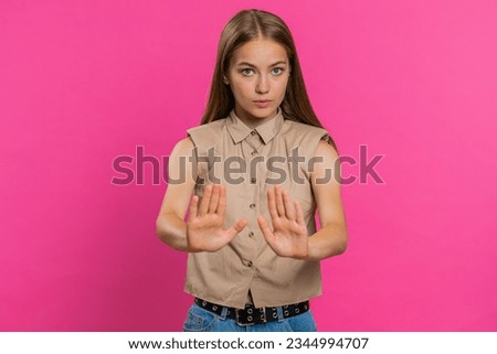 Hey you, be careful, slowly. Young woman warning with admonishing finger gesture, saying no, be careful, scolding and giving advice to avoid danger disapproval sign. Girl isolated on pink background