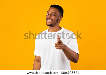 Hey, You. Positive African Guy Pointing Fingers At Camera Posing On Yellow Background. Studio Shot