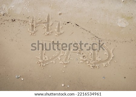 Hi Dad written on the beach in the sand