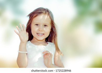 Hi Dear, Greeting Someone. Happy Smiling Woman Waving Hand Waving Over Shoulder Looking Away To A Friend Outdoors, Green Tree On Background