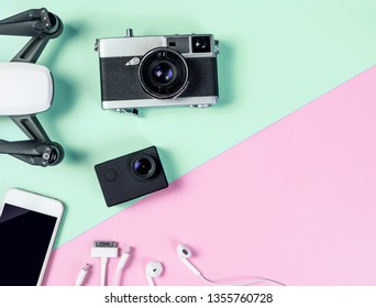 Hi tech Chic Female travel gadgets and accessories on blue and pink copy space for Videography Objects including Drone Action Cam and Mobile phone for Blogger and Vlogger concept - Shutterstock ID 1355760728