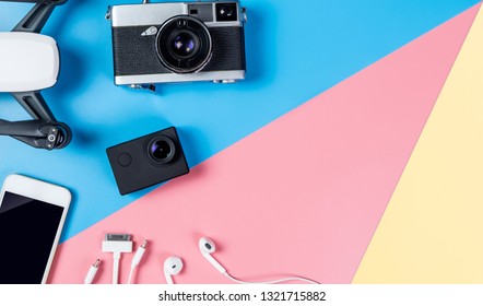 Hi tech travel gadget and accessories and mobile phone on blue yellow pink copy space with drone action camera for portable vlogging concept - Shutterstock ID 1321715882