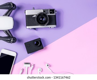 Hi tech travel Photographer gadget and accessories with camera action cam drone and mobile phone on purple and pink copy space for Modern Traveler blogger concept - Shutterstock ID 1341167462