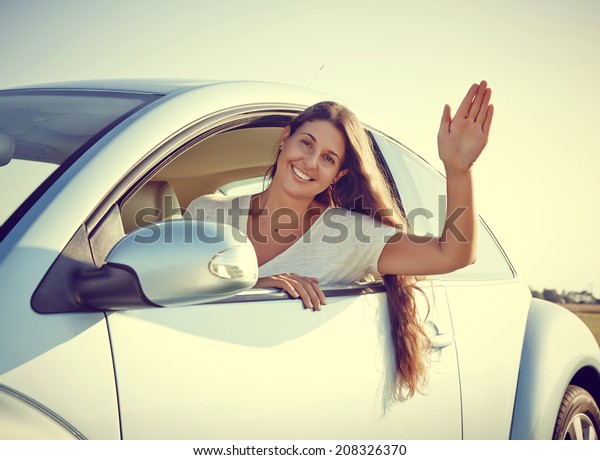 Hi - Young driver Woman Waving out of her new car,\
rental car.
