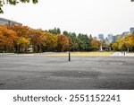 Hibiya Park, empty square without people and coloured trees at the grand fountain outdoor in the park in Chiyoda city in Tokyo during autumn in fall season in Japan.