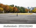 Hibiya Park, empty square without people and coloured trees at the grand fountain outdoor in the park in Chiyoda city in Tokyo during autumn in fall season in Japan.