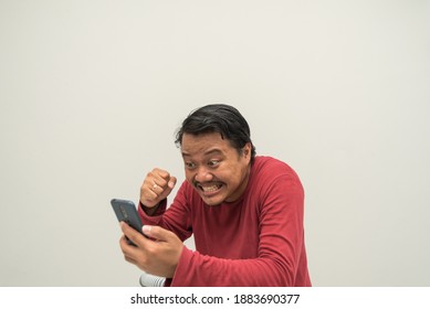 Hiccup Expression Of  Young Man Looking At Mobile Phone On Light Brwon Background. Bad Time Management, Emotional Reaction, Stress Concept