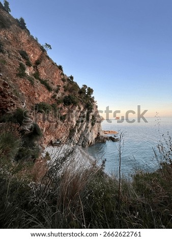 Hidden beach surrounded by dramatic red cliffs and crystal-clear waters in the soft light of sunset. A peaceful and secluded gem for nature lovers and adventure seekers.