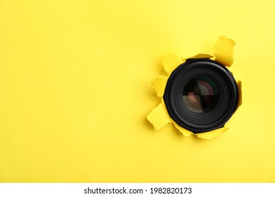 Hidden Camera Lens Through Hole In Yellow Paper. Space For Text