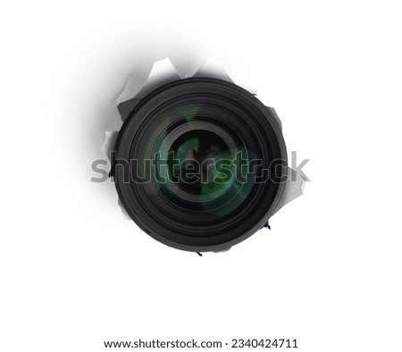 Hidden camera lens through hole in white paper,Concept of paparazzi or hidden camera