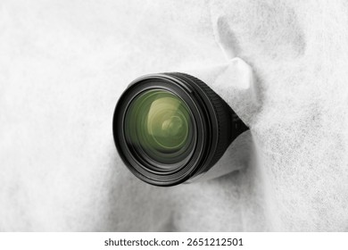 Hidden camera lens through torn hole in white fabric