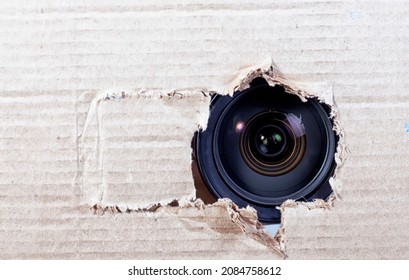 Hidden Camera Lens In The Torn Hole Of Cardboard Paper