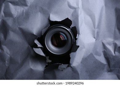 Hidden Camera Spying Through Torn Hole In Black Paper