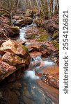 A hidden corner in the Pyrenees, where the river meanders through the beech forest covered with autumn leaves, creating an enchanted atmosphere near the mountains of Hoz de Jaca and Panticosa.