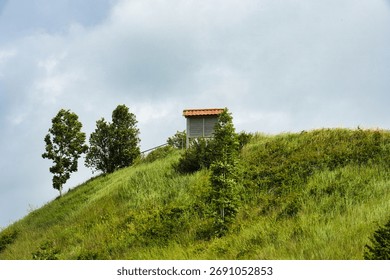 Hidden Hilltop Structure Under Cloudy Sky