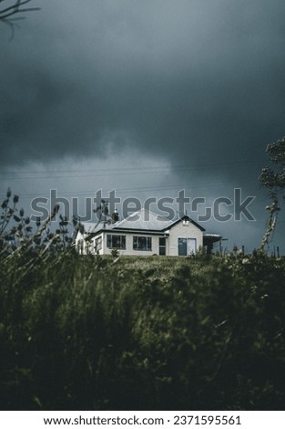 Hidden Home Amongst a Dark Storm with Dark and Moody Clouds