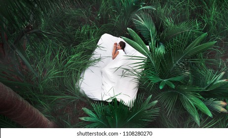 Ein versteckter Ort. Schlafende Frau im tiefen Dschungelwald liegt auf dem Bett,Aussicht von oben