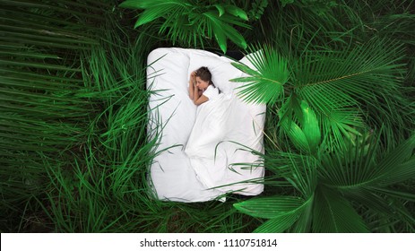 Ein versteckter Ort. Schlafende Frau im tiefen Dschungelwald liegt auf dem Bett,Aussicht von oben