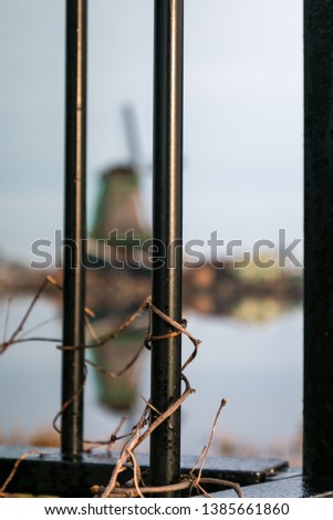 Hidden windmill seen through bars at Zaanse Schans