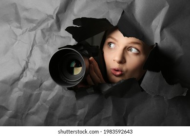 Hidden Woman With Camera Spying Through Hole In Black Paper