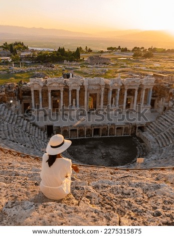 Hierapolis ancient city Pamukkale Turkey, a young woman with a hat watching the sunset by the ruins Unesco. Asian women watching sunset at the old Amphitheater in Turkey 