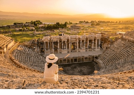 Hierapolis ancient city Pamukkale Turkey, a young woman with a hat watching the sunset by the ruins Unesco Heritage. Asian women watching the sunset at the old Amphitheater in Turkey during holiday