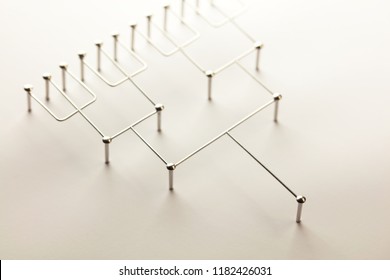 Hierarchy, command chain, company / organization structure or layer concept image. Top down structure made from chrome wires and chrome nails on white. Shallow depth of field. incandescent type light. - Shutterstock ID 1182426031