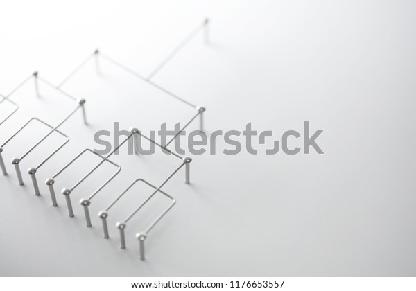 Hierarchy, command\
chain, company / organization structure or layer concept image. Top\
down structure made from chrome wires and chrome nails on white.\
Shallow depth of\
field.
