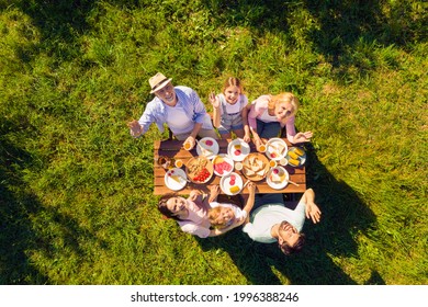 High above angle view family having picnic outdoors cheerful waving hands sunny summer day - Powered by Shutterstock