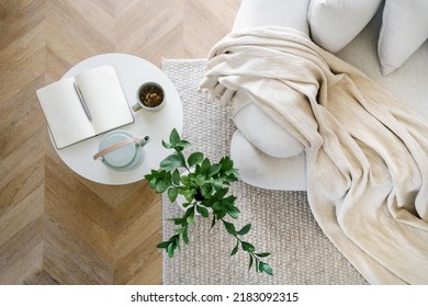 High above view of open book, plant, tea and couch in living room interior design. Home comfort concept. Relax idea. Flat lay. House details - Shutterstock ID 2183092315