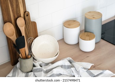 High above view of wooden cutting board, kitchenware and utensils on table in kitchen. Home comfort concept. Eco-friendly kitchenware. Cooking at home