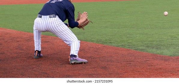 A High Achool Third Baseman Fielding A Ground Ball During A Game Close Up.