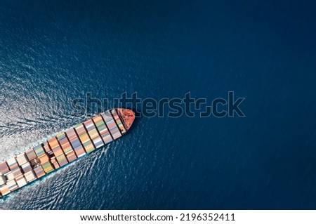 High aerial top down view of a large container cargo ship in motion over open ocean with copy space as a concept for import and export industry