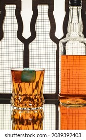 high alcohol whiskey colored ice blocks and bottle drink concept in close-up glass