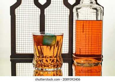 high alcohol whiskey colored ice blocks and bottle drink concept in close-up glass