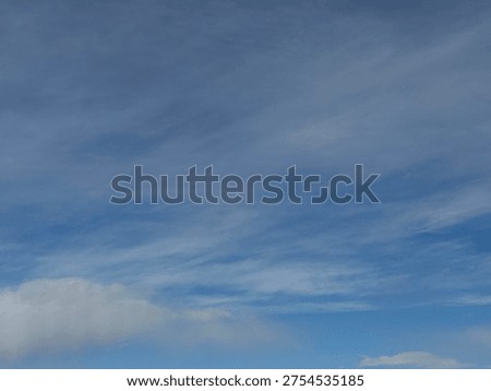 High altitude cloud formations drifting across soft blue sky creating natural atmospheric texture